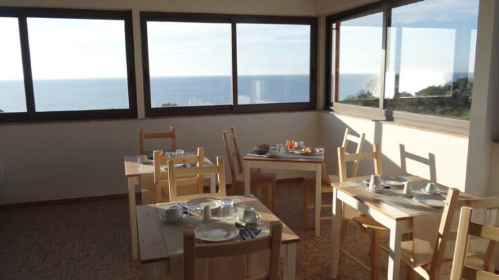 Scorcio della sala colazione dell'Agriturismo La Valle degli Ulivi con vista sul mare e sull'oliveto circostante
